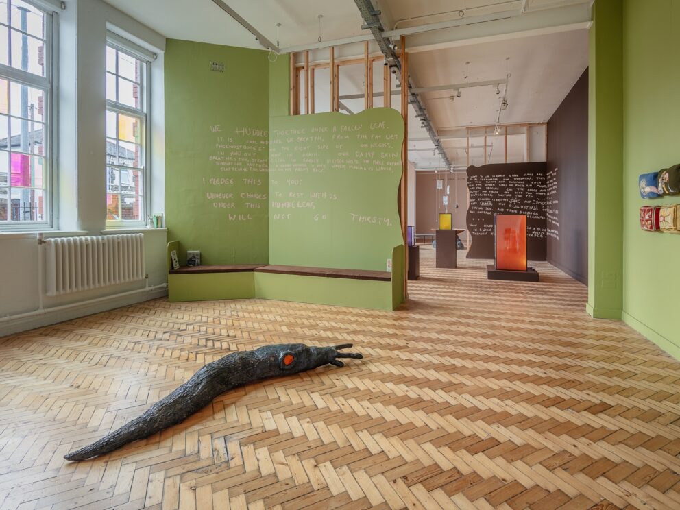 An installation view of Abi Palmer's exhibition Slime Mother, featuring a sculpture of a slug on the floor of a gallery