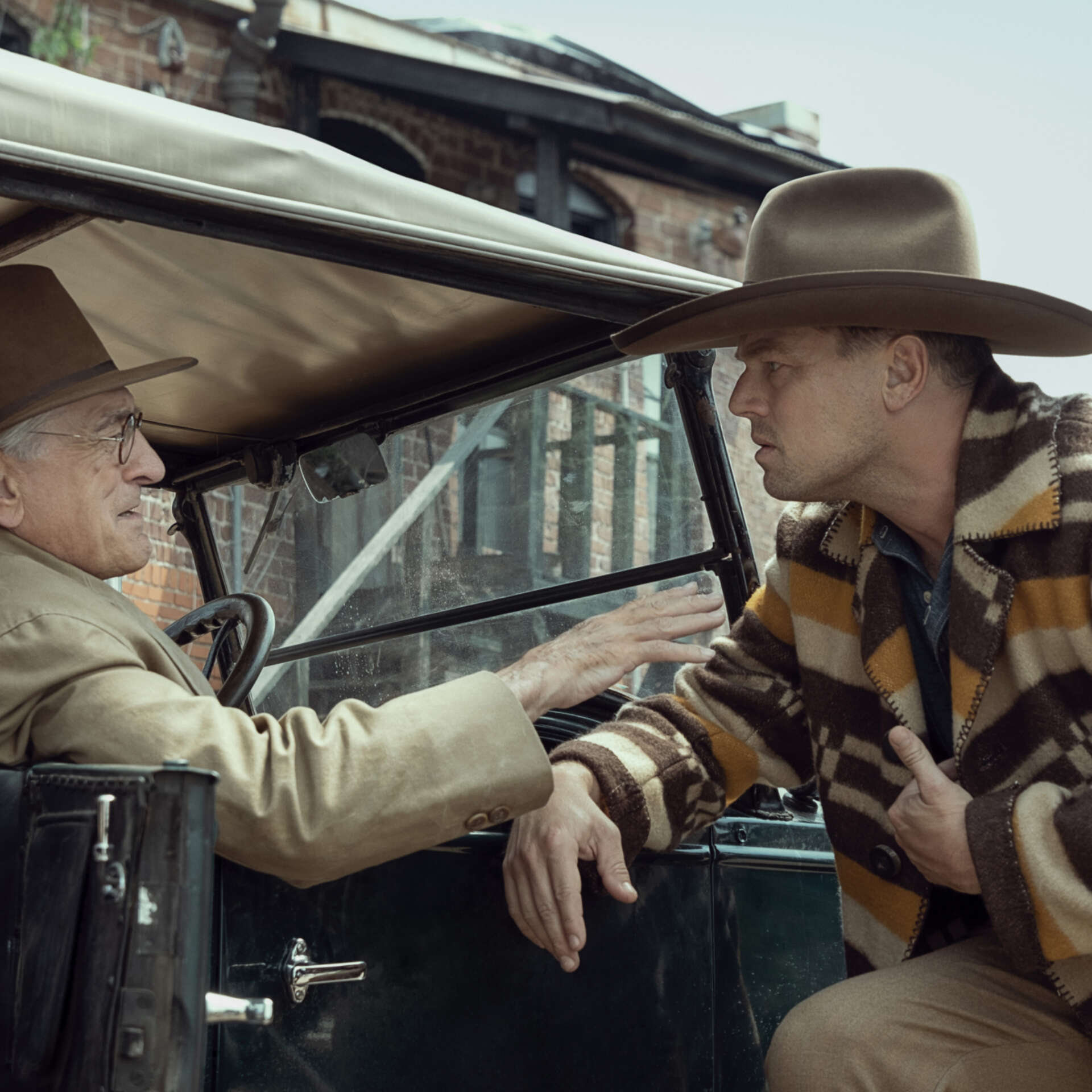 Robert DeNiro and Leonardo DiCaprio talk to each other in a 20s themed film set. Still image from Killers of the Flower Moon.